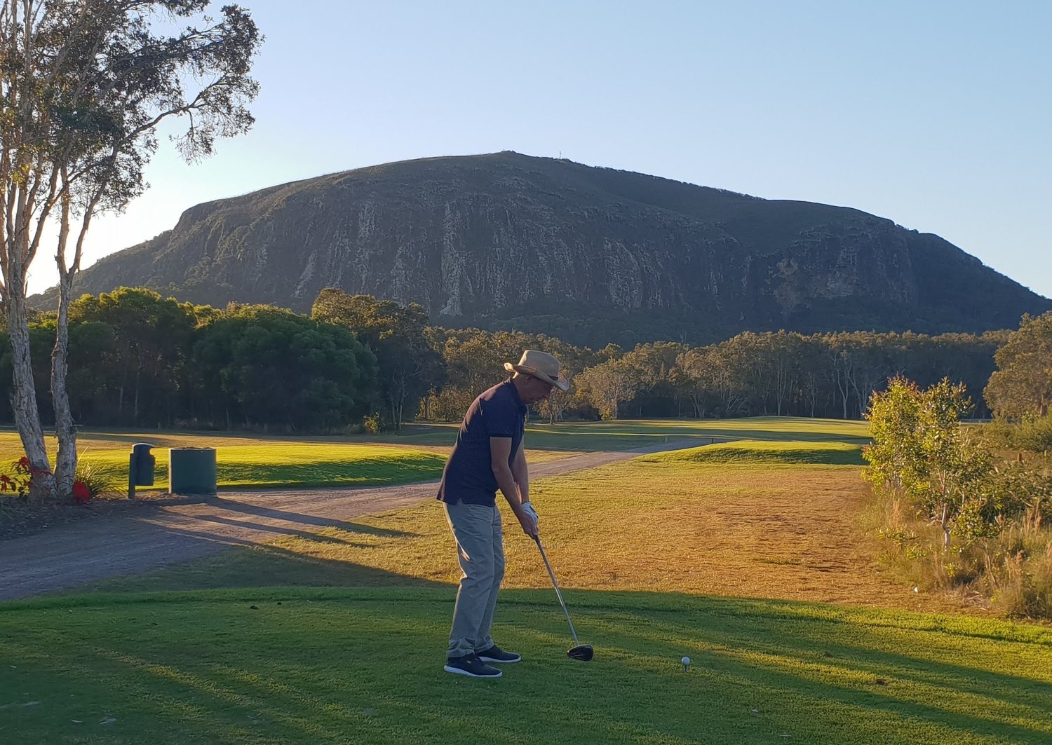 Original phone photo of a golfer teeing off beneath Mt Coolum